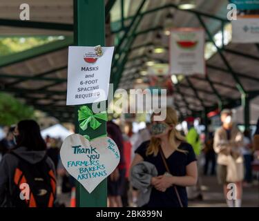 Davis, Californie, États-Unis. 2 mai 2020. Des signes qui ont fait rage sur la distance sociale des agriculteurs, qui est restée ouverte malgré le maintien. Les tentes sont plus répandues et seuls les fournisseurs peuvent toucher les produits. L'argent et les produits sont gérés par différentes personnes. Un poste de lavage des mains est offert et presque tout le monde porte des masques. Banque D'Images