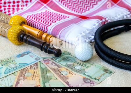 Ensemble de gros plan de foulard arabe châle keffiyeh ou kafiya, Igal ou AGAL, billets de banque arabe Émirats Arabes Unis Dirhams, ballon de golf et accessoires de Hookah. Banque D'Images