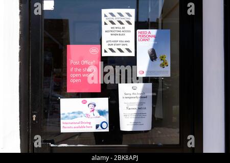 Une signalisation sur la porte d'un magasin indique aux clients que le magasin est fermé en raison de Covid-19. Banque D'Images