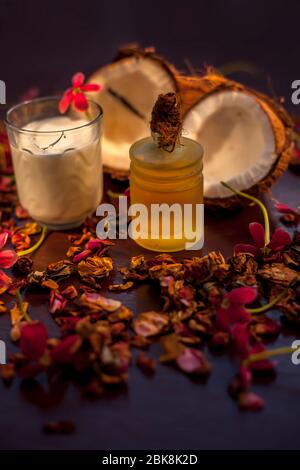 Le masque de face de noix de coco sur la surface marron composée d'un peu de lait de coco et d'huile d'olive lorsqu'il est appliqué pénètre la peau et exfolié profondément. F Banque D'Images