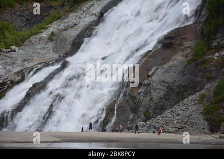 Les touristes se tiennent près des chutes de Nugget au glacier Mendenhall près de Juneau, en Alaska. Banque D'Images