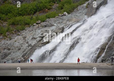 Les touristes se tiennent près des chutes de Nugget au glacier Mendenhall près de Juneau, en Alaska. Banque D'Images