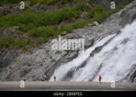 Les touristes se tiennent près des chutes de Nugget au glacier Mendenhall près de Juneau, en Alaska. Banque D'Images