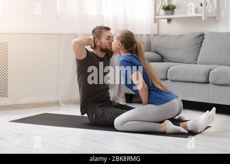 Jeune couple en amour de l'entraînement à la maison et s'embrasser Banque D'Images