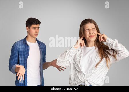 Jeune couple se querelant, fille couvre les oreilles avec les mains Banque D'Images