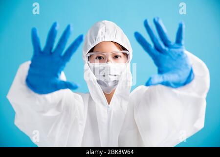 infirmière féminine portant un masque médical avec lunettes de sécurité et un costume de protection blanc. montrant un arrêt et aucun geste de signe Banque D'Images