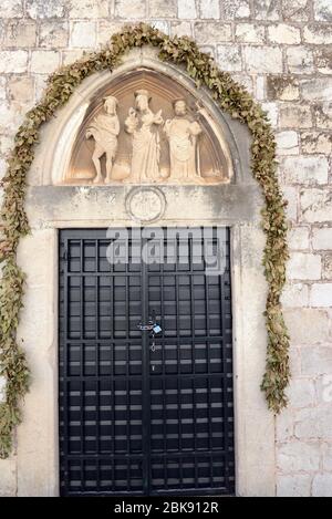 Jésus Christ, Saint Jean Baptiste et Saint Nicolas avec un bâton, portail de l'église Saint Luc à Dubrovnik, Croatie Banque D'Images