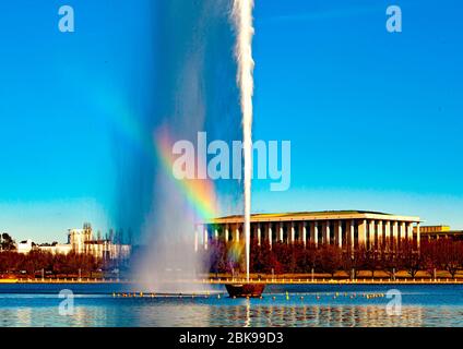 Arc-en-ciel à bord d'un jet d'eau Captain Cook Memorial sur le lac Burley Griffin à Canberra, capitale nationale de l'Australie, avec la Bibliothèque nationale en arrière-plan Banque D'Images