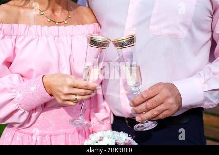 Mariée et marié avec verres à champagne et bouquet de mariée Banque D'Images