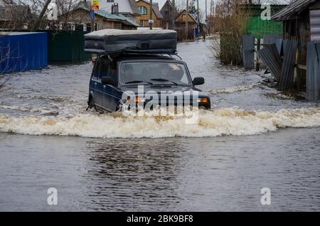 2020 mai - Arkhangelsk. La voiture russe tout-terrain Niva roule sur une route inondée. Russie, région d'Arkhangelsk Banque D'Images