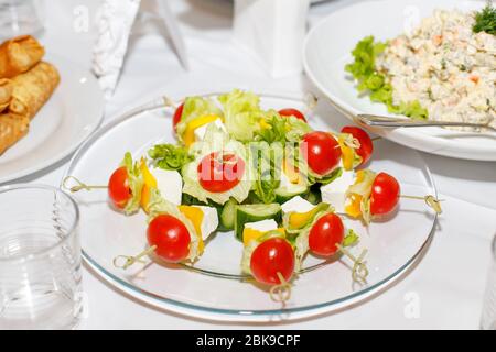 Canapés aux tomates, concombres, fromages et légumes verts sur une table de banquet Banque D'Images