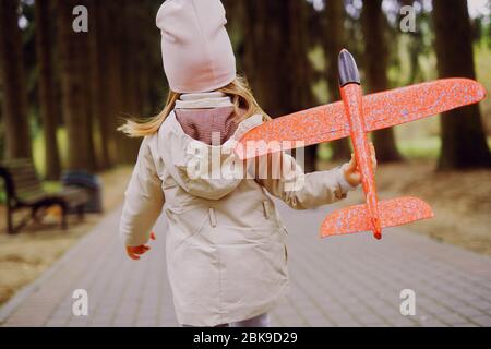 une fille joue avec un avion jouet Banque D'Images