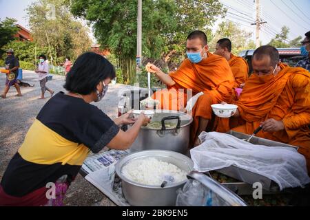 Ayutthaya, Thaïlande. 02 mai 2020. Une femme portant un masque de visage reçoit de la nourriture d'un moine assis à l'arrière d'un camion de ramassage au milieu de la crise du coronavirus.pendant la crise du coronavirus à côté du gouvernement, de nombreuses organisations ont été sorties pour soutenir les personnes vulnérables. Crédit: SOPA Images Limited/Alay Live News Banque D'Images