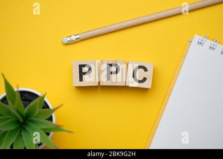 Mot de buzzWord de marketing moderne PPC - payer par clic. Vue sur la table en bois avec des blocs. Vue de dessus. Gros plan. Banque D'Images