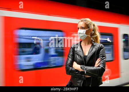 Femme avec masque respiratoire, en attente de train, S-Bahn, Corona Crisis, Stuttgart, Bade-Wuerttemberg, Allemagne Banque D'Images