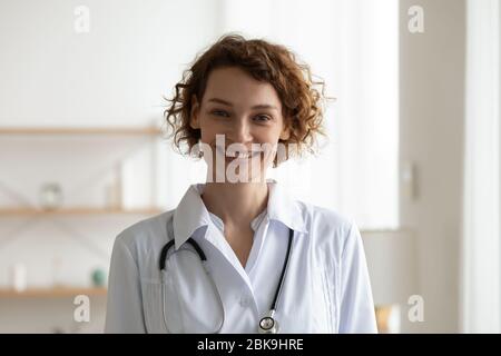 Jeune femme souriante médecin portant un manteau médical blanc portrait de tête Banque D'Images