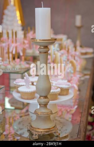 Festival, dîner, vacances, nouvel an . Bar Candy rose . Porte-bougie en laiton . Bougie isolée sur l'arrière-plan flou. Bougie pour dîner de nuit, Banque D'Images