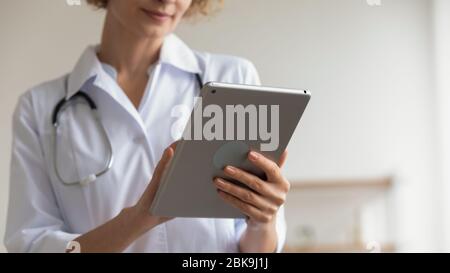 Médecin de femme tenant un tampon moderne à l'aide d'applications de tablette numérique, gros plan Banque D'Images