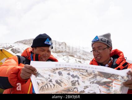 Lhasa. 2 mai 2020. Xue Qiangqiang (L) et son coéquipier voient une carte dans le camp de base du Mont Qomolangma dans la région autonome du Tibet du sud-ouest de la Chine, le 2 mai 2020. C'est la première fois que Xue Qiangqiang, 37 ans, monte au mont Qomolangma, le plus haut sommet du monde. Il est membre d'une équipe chinoise pour mesurer à nouveau la hauteur de la montagne en mai. POUR ALLER AVEC "Feature: Les arpenteurs chinois se préparent à remesurer Mt. Crédit de Qomolangma: Purbu Zhaxi/Xinhua/Alay Live News Banque D'Images