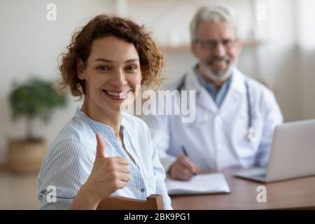 Une femme en bonne santé satisfaite regardant l'appareil photo montrant les pouces vers le haut Banque D'Images