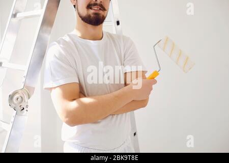 Peintre maison en uniforme blanc sur fond blanc pour peindre dans la salle. Banque D'Images