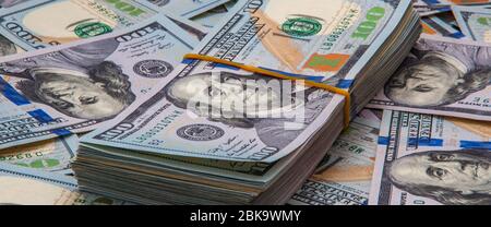 Un paquet de dollars sur le fond de factures éparses de cent dollars Banque D'Images