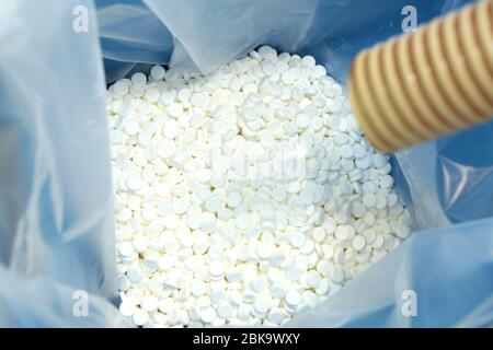 Production de tablettes. Comprimés versés dans un emballage stérile. Beaucoup de pilules. Fabrication de comprimés blancs et ronds pour la santé. Banque D'Images