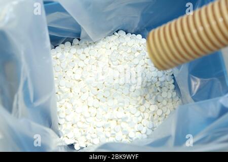 Production de tablettes. Comprimés versés dans un emballage stérile. Beaucoup de pilules. Fabrication de comprimés blancs et ronds pour la santé. Banque D'Images