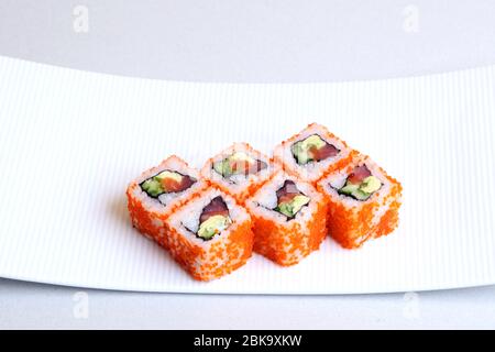 Sushi. Petits pains aux crevettes. Rouler en Californie avec de l'avocat. Cuisine japonaise. Les aliments sains sont bien disposés sur un plateau. Plat avec riz. Banque D'Images