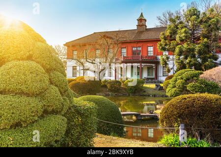 tokyo, japon - 20 mars 2020: L'étang du jardin japonais des jardins botaniques de Koishikawa avec la maison de maître en brique rouge de l'annexe de Koishikawa Banque D'Images