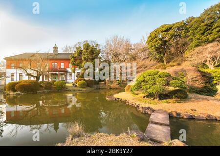 tokyo, japon - 20 mars 2020: L'étang du jardin japonais des jardins botaniques de Koishikawa avec la maison de maître en brique rouge de l'annexe de Koishikawa Banque D'Images