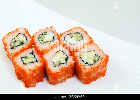 Sushi. Petits pains aux crevettes. Rouler en Californie avec de l'avocat. Cuisine japonaise. Les aliments sains sont bien disposés sur un plateau. Plat avec riz. Banque D'Images