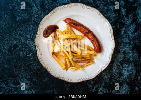 Saucisse maison avec pommes de terre aux frites Skinny dans la plaque également appelée Salchilapa péruvien. Restauration rapide. Banque D'Images