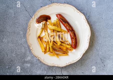 Saucisse maison avec pommes de terre aux frites Skinny dans la plaque également appelée Salchilapa péruvien. Restauration rapide. Banque D'Images