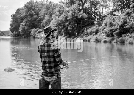 Je pêche. Activités de loisir et de sport. Pothunter. Week-end d'été. Pêche au gros gibier. Pêcheur avec canne à pêche. Pêcheur barbu dans l'eau. Homme mature pêche à la mouche. Homme attrapant le poisson. Banque D'Images