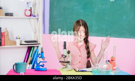 Notre objectif est de trouver le remède. Jeune fille étudier la chimie avec tube à essai. Retour à l'école. Formation en biologie. Leçon de science avec microscope. Laboratoire scolaire. Technologie moderne. Petite fille avec flacon de laboratoire. Banque D'Images