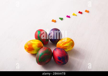 Lettres en bois multicolores composant les mots Happy easter et œufs colorés décoratifs sur fond blanc avec espace de copie. Banque D'Images