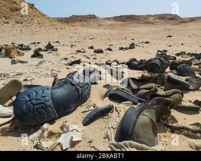 Gros plan sur les vieilles bottes militaires en décaissement abandonnées dans le désert africain éloigné Banque D'Images