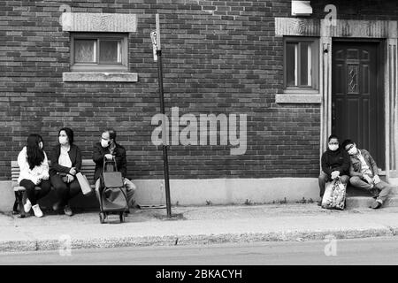 Les gens qui attendent l'autobus pendant la pandémie de Covid 19 , dans Park extension, un quartier immigrant de Montréal Canada Banque D'Images