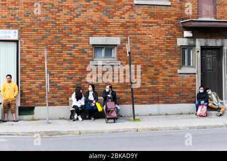 Les gens qui attendent l'autobus pendant la pandémie de Covid 19 , dans Park extension, un quartier immigrant de Montréal Canada Banque D'Images