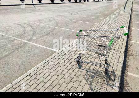 Vider le chariot d'épicerie dans un stationnement vide près d'un centre commercial. Concept de crise financière. Problèmes des petites entreprises et des vendeurs privés pendant le Banque D'Images
