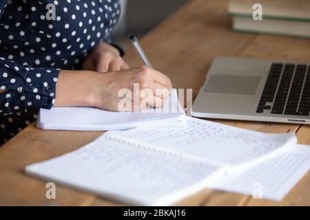 Femme millénaires ciblée notant des informations importantes, assise à la table. Banque D'Images