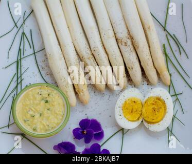 Bouquet d'asperges blanches fraîches non cuites et d'œufs durs, nouvelle récolte, gros plan. Effet de filtre. Légumes de saison. Mise au point sélective Banque D'Images