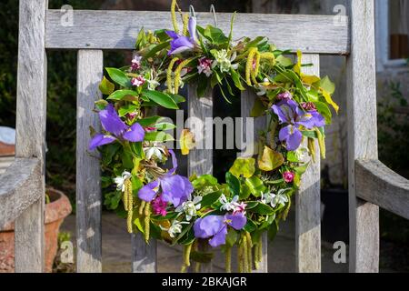 couronne faite de fleurs de printemps fraîches, daphné doux, chatons, pinks, gouttes d'eau, lierre, mousse, iris de printemps Banque D'Images