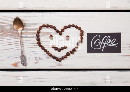 Visage souriant avec tête en forme de coeur et cuillère à café. Banque D'Images