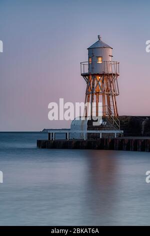 Le phare du village suédois Raa à la périphérie d'Helsingborg au coucher du soleil. Banque D'Images