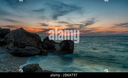 Une longue exposition photograhy à rocky Kato Petres paysage plage au crépuscule. Rhodes, Grèce Banque D'Images