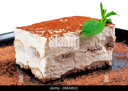 gâteau tiramisu sur une plaque noire. délicieux dessert italien décoré de menthe Banque D'Images