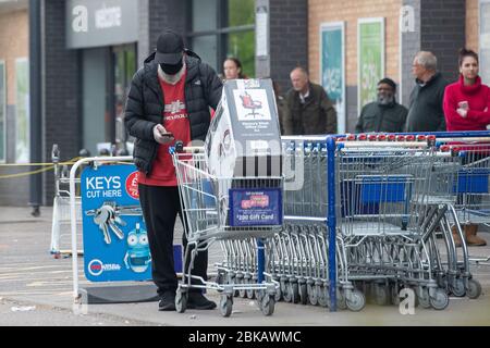 Un homme pousse un chariot transportant une chaise de bureau loin de la chaîne de Leicester alors que le Royaume-Uni continue à se verrouiller pour aider à freiner la propagation du coronavirus. Banque D'Images