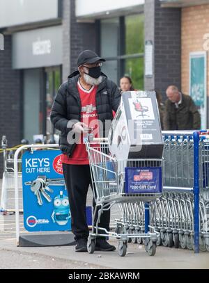 Un homme pousse un chariot transportant une chaise de bureau loin de la chaîne de Leicester alors que le Royaume-Uni continue à se verrouiller pour aider à freiner la propagation du coronavirus. Banque D'Images